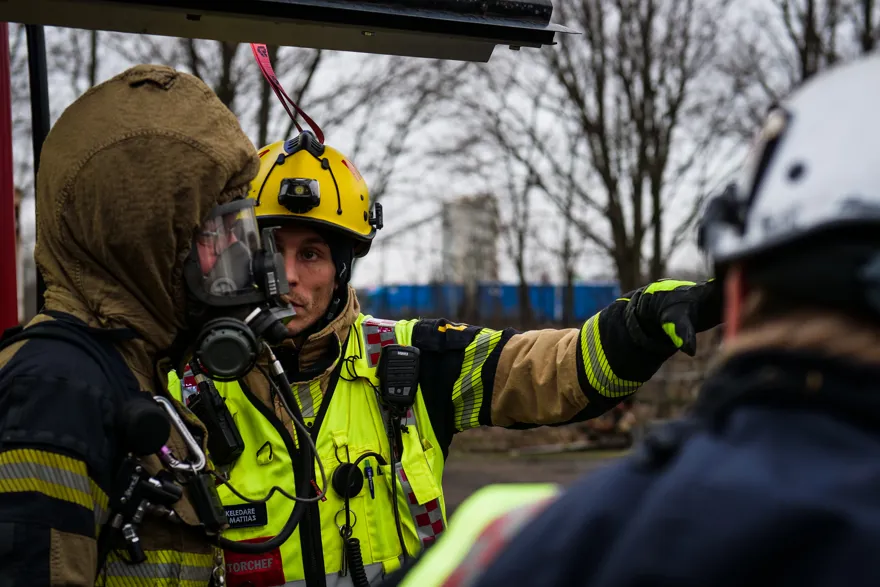 Brandbefäl ger instruktion till brandman i andningsskydd